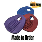 Three textured silicone pads in blue, purple, and red with 'Grind Ring' branding on a white background.